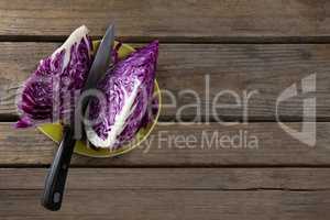 Sliced red cabbage in plate on wooden table