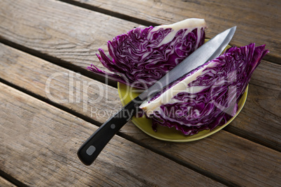 Sliced red cabbage in plate on wooden table