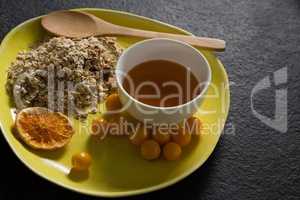 Dried orange slice, oatmeal, golden berry and maple syrup in plate