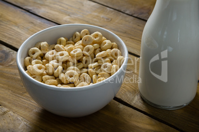 Cereal rings and milk on wooden table