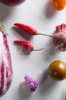Overhead view of red chili peppers with eggplant