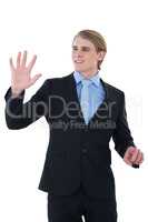 Smiling young businessman gesturing on invisible interface