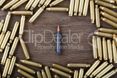 Ak-47 cartridges on wooden table close-up.
