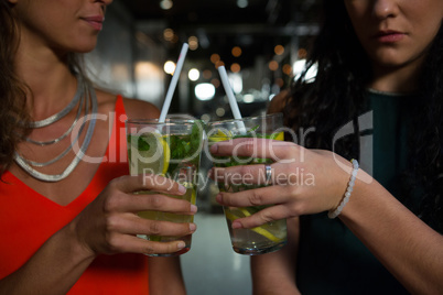 Mid section of friends toasting mocktails