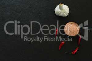 Garlic, red chili pepper and salt on black background