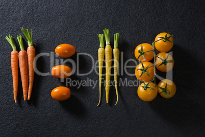 Carrots and tomatoes on black background