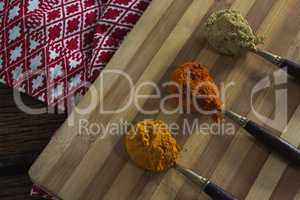 Turmeric powder, red chili powder, coriander powder on chopping board