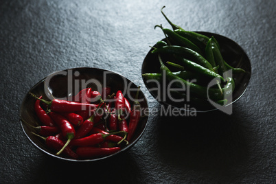 Green and red chili pepper in bowl