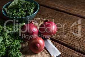 Mustard greens and onions on wooden table
