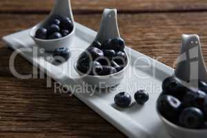 Blueberries in spoon arranged on tray