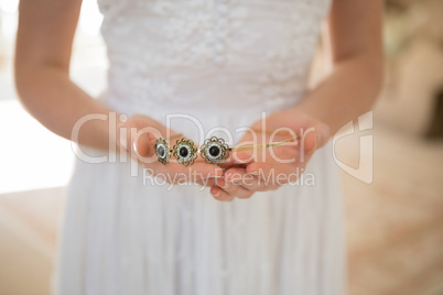 Midsection of bride holding tiara at home