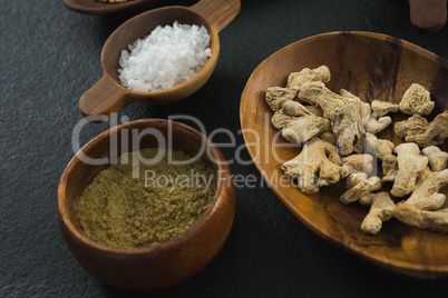 Dried ginger and coriander powder on black background
