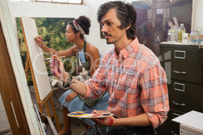 Man and woman painting on canvas