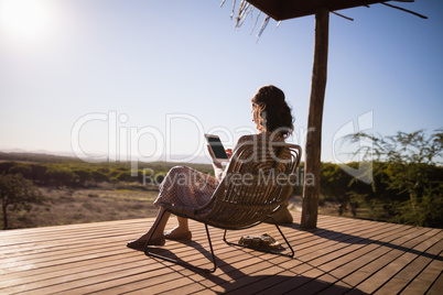 Senior woman using digital tablet while sitting