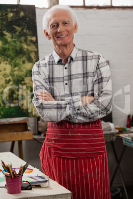 Portrait of happy man standing with arms crossed