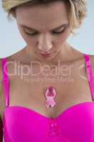 Close up of woman in pink bra with Breast Cancer Awareness ribbon