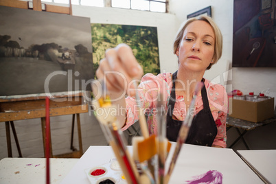 Woman selecting a paintbrush
