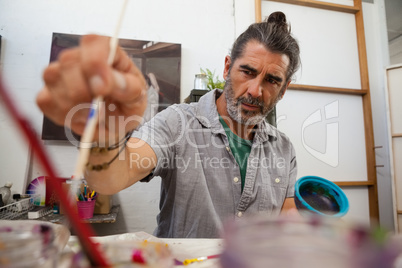 Attentive man painting bowl