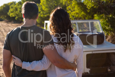 Rear view of couple by vehicle