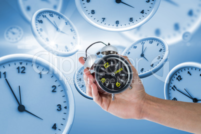 Composite image of cropped hand of man holding alarm clock