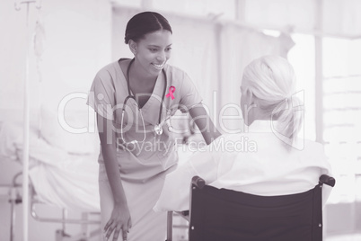 Composite image of smiling nurse assisting female patient in wheelchair