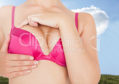 Breast cancer woman with sky clouds background checking in bra
