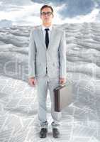 Businessman in sea of documents under sky clouds with briefcase