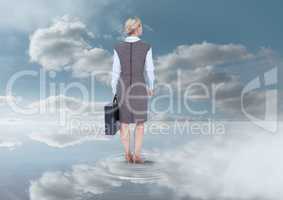 Businesswoman holding briefcase under sky clouds