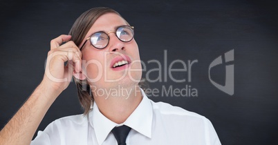 Close up of nerd man scratching head against navy chalkboard