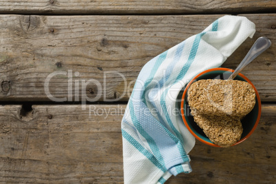 Granola bar and spoon with napkin on wooden table