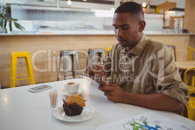 Young man using digital tablet at cafe