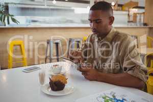 Young man using digital tablet at cafe