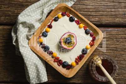 Fruit yogurt and honey on a wooden table