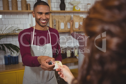 Owner receiving payment from customer in cafe