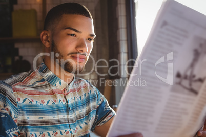 Man reading newspaper in cafe