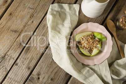 Plate of breakfast cereals with fruits on wooden table