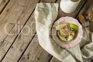 Plate of breakfast cereals with fruits on wooden table