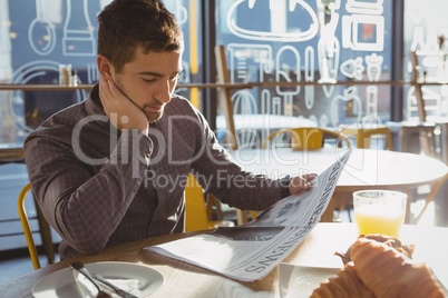 Businessman reading newspaper in cafe