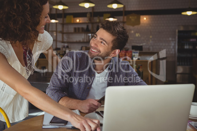 Happy business people looking each other in cafe