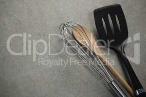 High angle view of wire whisk and wooden spoon by spatula