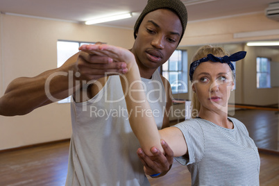 Young man assisting female friend in dance