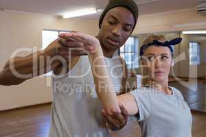 Young man assisting female friend in dance