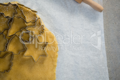 Close up of various shape cutters over pastry dough