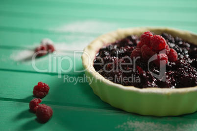 Blackberries and raspberries on tart in baking pan