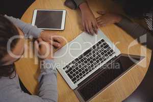 High angle view of friends using laptop at table