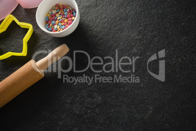 Pastry cutters and rolling pin with candies in bowl