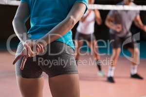 Mid section of player gesturing at volleyball court