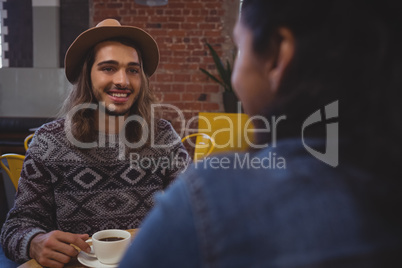Man looking at friend in cafe