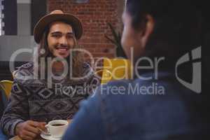 Man looking at friend in cafe