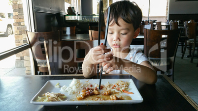 Cute Young Chinese and Caucasian Boy Learning To Use Chopsticks